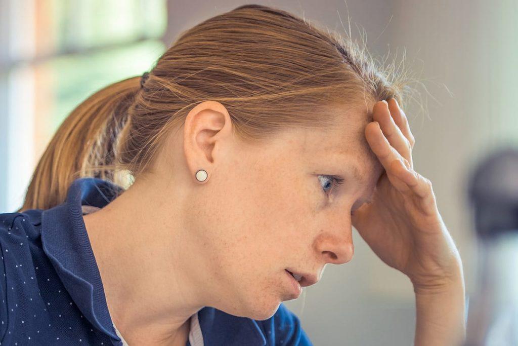 Gestresste Frau mit Hand am Kopf